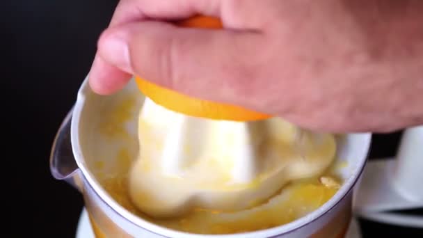 Κοντινό πλάνο του χεριού στύψιμο ενός πορτοκαλιού με αποχυμωτή — Αρχείο Βίντεο