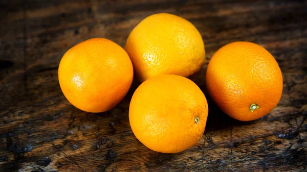 Close-up de quatro laranjas na mesa de madeira — Fotografia de Stock