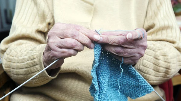 Großaufnahme einer älteren Frau, die einen Schal strickt — Stockfoto