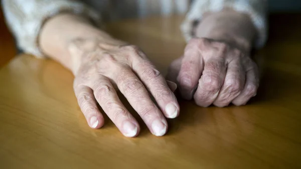 Nahaufnahme alter weiblicher Hände auf dem Tisch — Stockfoto