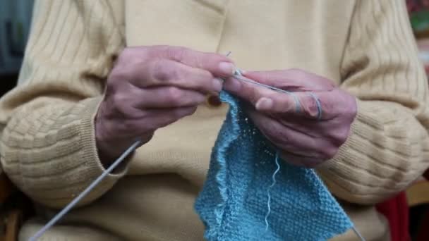 Крупный план пожилой женщины, вяжущей шарф — стоковое видео