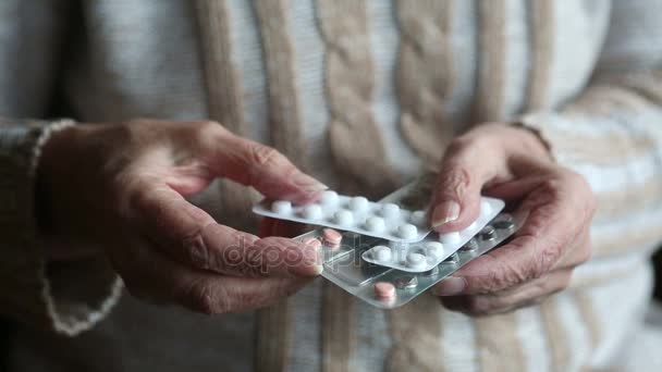 Closeup of old womans hands holding packages of medication — Stock Video