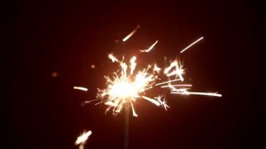 parlak kırmızı arka plan ile parlayan bir maytap