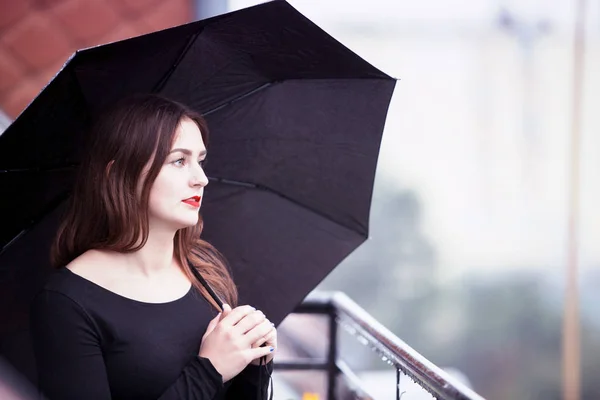 Młoda brunetka kobieta z parasol w deszczu — Zdjęcie stockowe