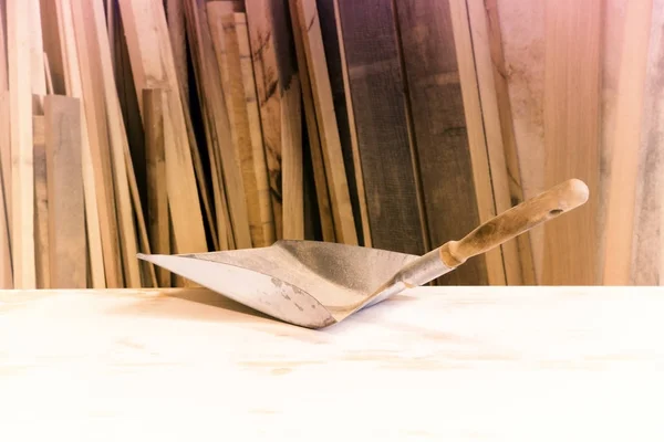 Старая лопата на столе перед кучей дерева — стоковое фото