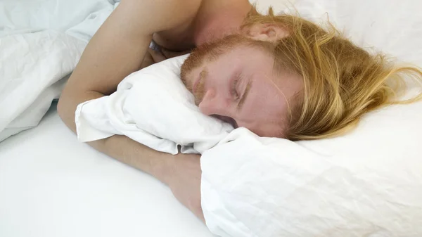 Schöner rothaariger Mann, der im Bett liegt und schläft — Stockfoto