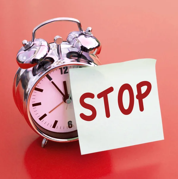 The word Stop written on paper on alarm clock — Stock Photo, Image