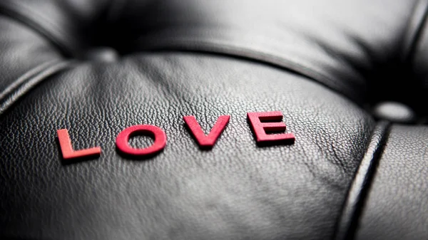 The word Love on black leather — Stock Photo, Image