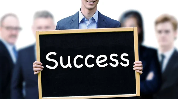 Young man in front of group holding sign with word Success — Stock Photo, Image