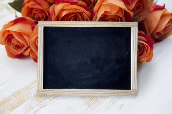 与橙色玫瑰空黑色的黑板 — 图库照片