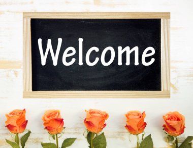 turuncu gül ve kara tahta ile kelime hoş geldiniz