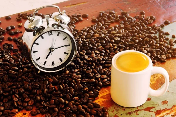 Grãos de café e xícara de café e despertador — Fotografia de Stock