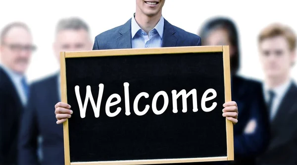 Joven hombre de negocios sosteniendo una pizarra con la palabra Bienvenido — Foto de Stock
