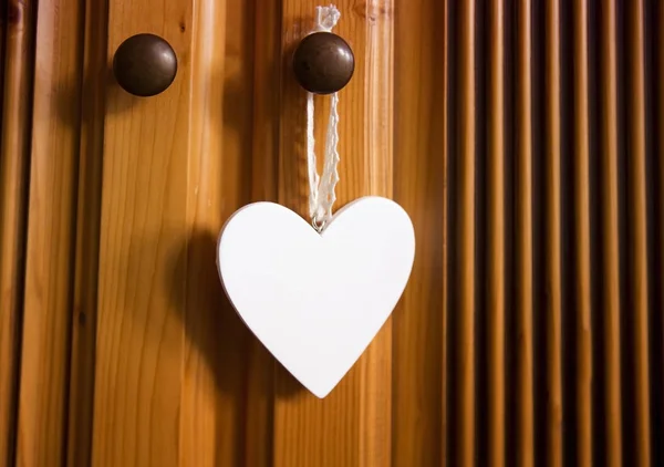 White heart hanging from wooden door — Stock Photo, Image