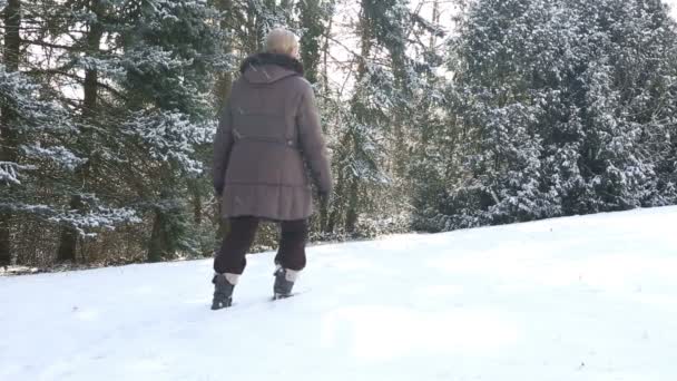 Παλαιότερο γυναίκα το περπάτημα σε βαθύ χιόνι σε εξωτερικούς χώρους — Αρχείο Βίντεο