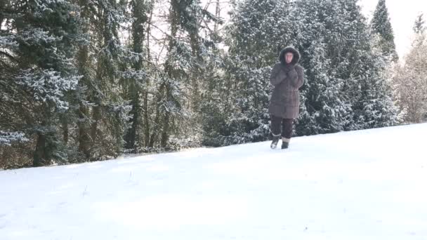 Mulher mais velha andando na neve profunda ao ar livre — Vídeo de Stock
