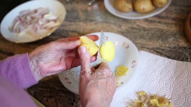 El cierre de las manos de mujeres mayores que cortan patatas — Vídeo de stock