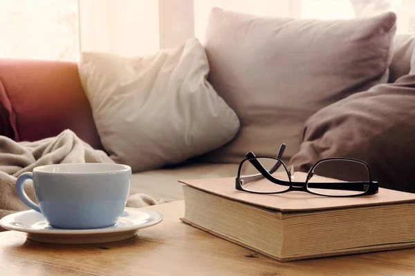 Cup en boek op tafel sofa — Stockfoto
