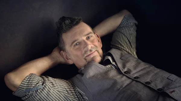 Porträtt av eleganta mannen i hans 50s liggande på soffan — Stockfoto