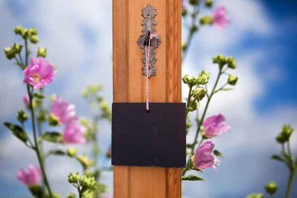 Μαυροπίνακας κρέμεται στο κλειδί μπροστά από το πεδίο των λουλουδιών — Φωτογραφία Αρχείου