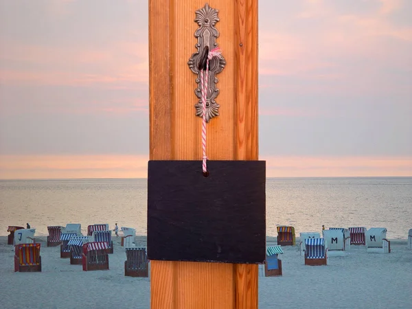 Tafel hängt am Schlüssel vor Strandkörben — Stockfoto