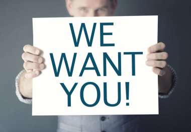 Biz Want You kelimelerle işaret tutan adam
