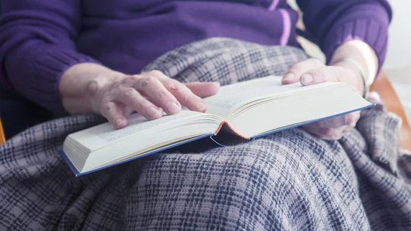 Gros plan de femme plus âgée assis par la fenêtre et la lecture d'un boo — Photo