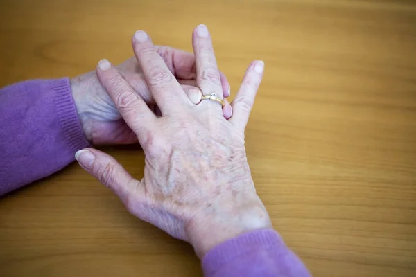 Nahaufnahme von älteren Frauenhänden, die einen Ring auf ihre Flosse legen — Stockfoto