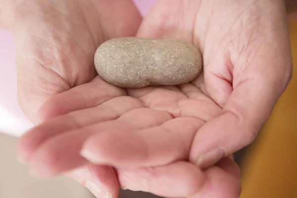 Närbild av kvinnans händer visar en sten — Stockfoto