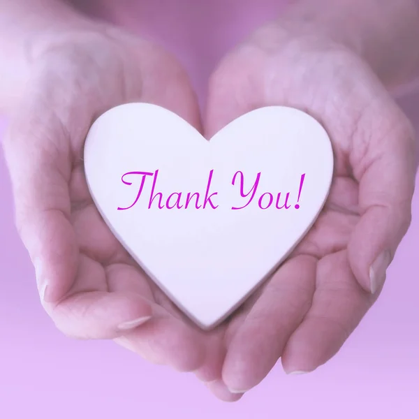 Las manos de las mujeres sosteniendo el corazón blanco con las palabras Gracias — Foto de Stock