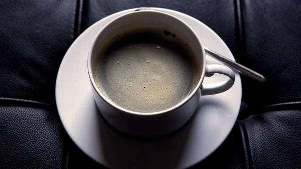 Koffiekopje op zwart luxe leer — Stockfoto