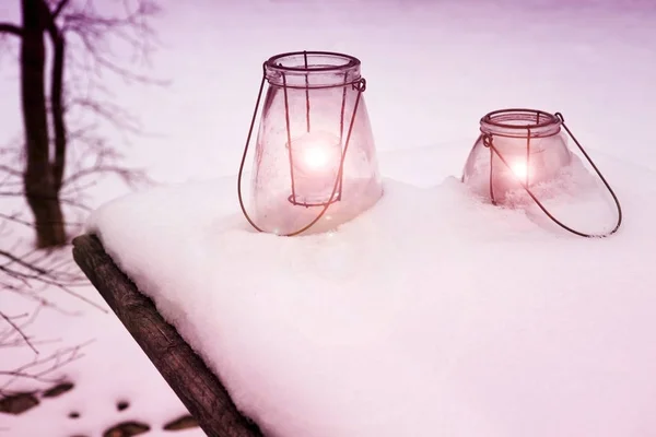 Zwei Laternen mit brennenden Kerzen im Schnee — Stockfoto