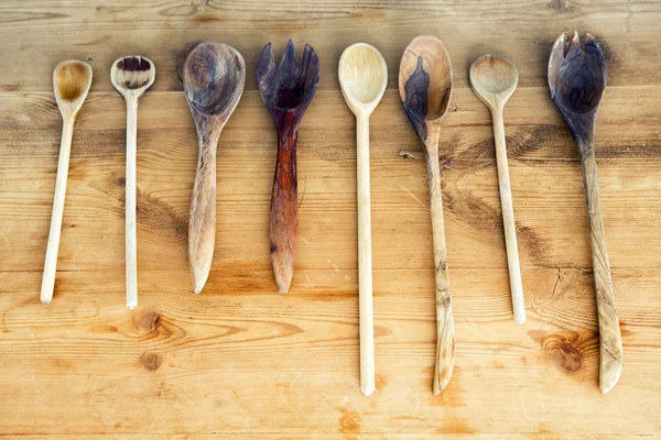 Cooking spoons lined up on wooden table — Stock Photo, Image