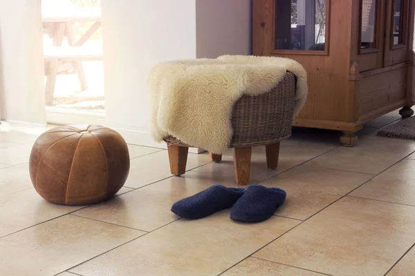 Stool with fleece and slippers in living room — Stock Photo, Image