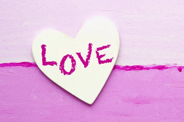 Λευκή καρδιά με τη λέξη αγάπη σε ροζ καμβά — Φωτογραφία Αρχείου