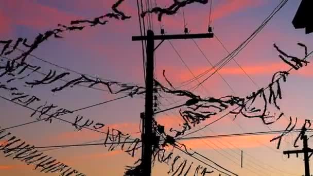 Bandeiras penduradas no poste elétrico ao pôr do sol no vento — Vídeo de Stock