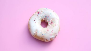 pembe bir arka plan üzerinde renkli Topingler ile dönen çörek