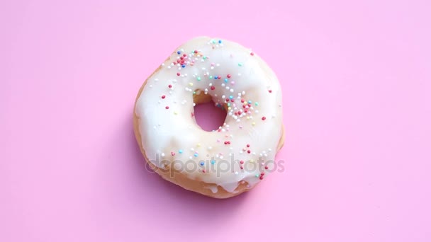 旋转与多彩浇头粉红色的背景上的甜甜圈 — 图库视频影像