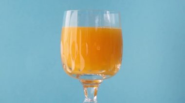 bardak portakal suyu mavi arka plan üzerinde döndürme