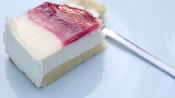 Rotating plate with piece of square cream cake — Stock Video