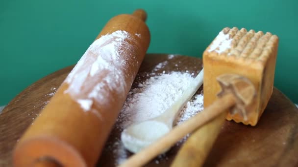 Tavola di legno rotante con cucchiaio da cucina e rullo di pasta e farina — Video Stock