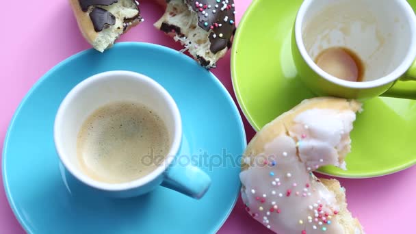 Plato rosado giratorio con dos tazas de café y rosquillas — Vídeo de stock