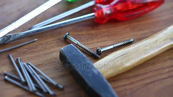 Hammer and screwdriver on rotating wooden board — Stock Video