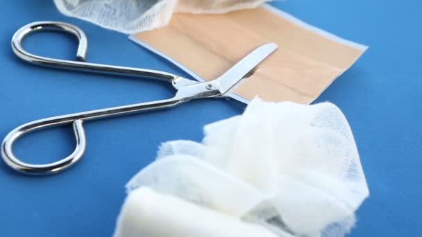 Obrotowy stół niebieski z bandaże i nożyczki — Wideo stockowe
