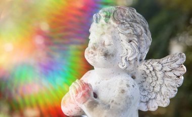 praying stone angel with colorful sunbeam clipart