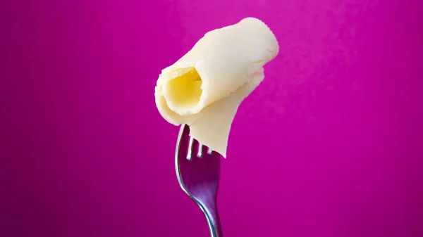 Gabel mit Scheibe Käse auf violettem Hintergrund — Stockfoto