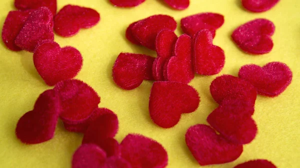 Close-up de pequenos corações suaves vermelhos na mesa amarela — Fotografia de Stock