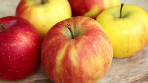 Gros plan de pommes sur une plaque tournante en bois — Video