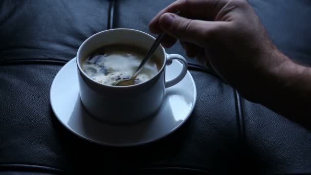 Close-up van mans hand een kopje koffie roeren en drinken — Stockvideo