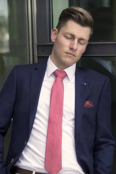Красивый мужчина в костюме прислонился к окну и спал — стоковое фото